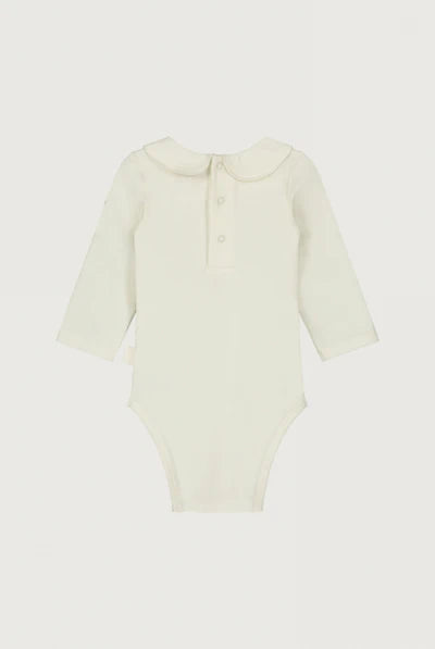 A long-sleeve baby bodysuit in a soft cream or off-white color, the back a three-button henley neckline, displayed flat against a light off-white background.