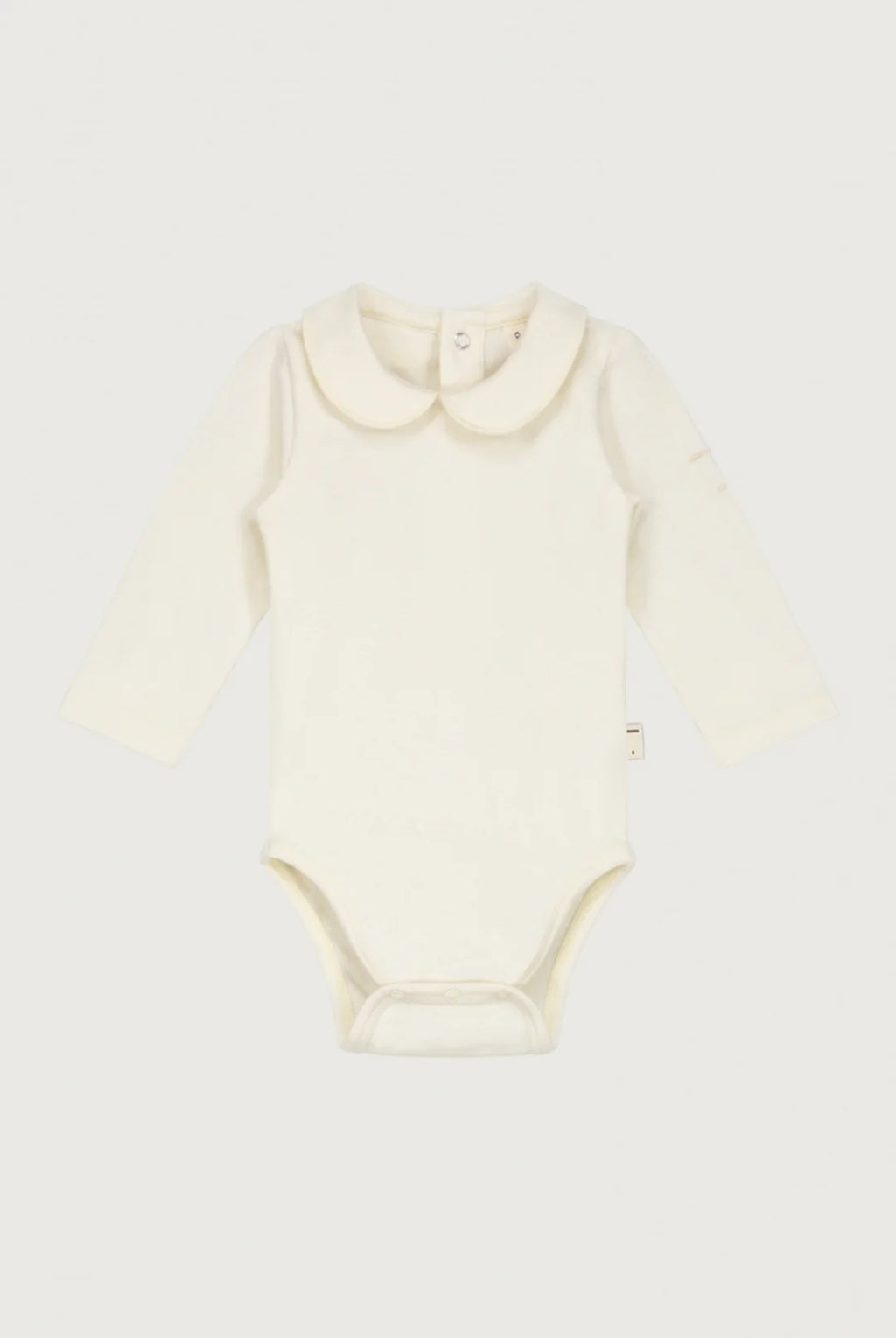An off-white long-sleeve baby bodysuit laid flat against a light gray background.