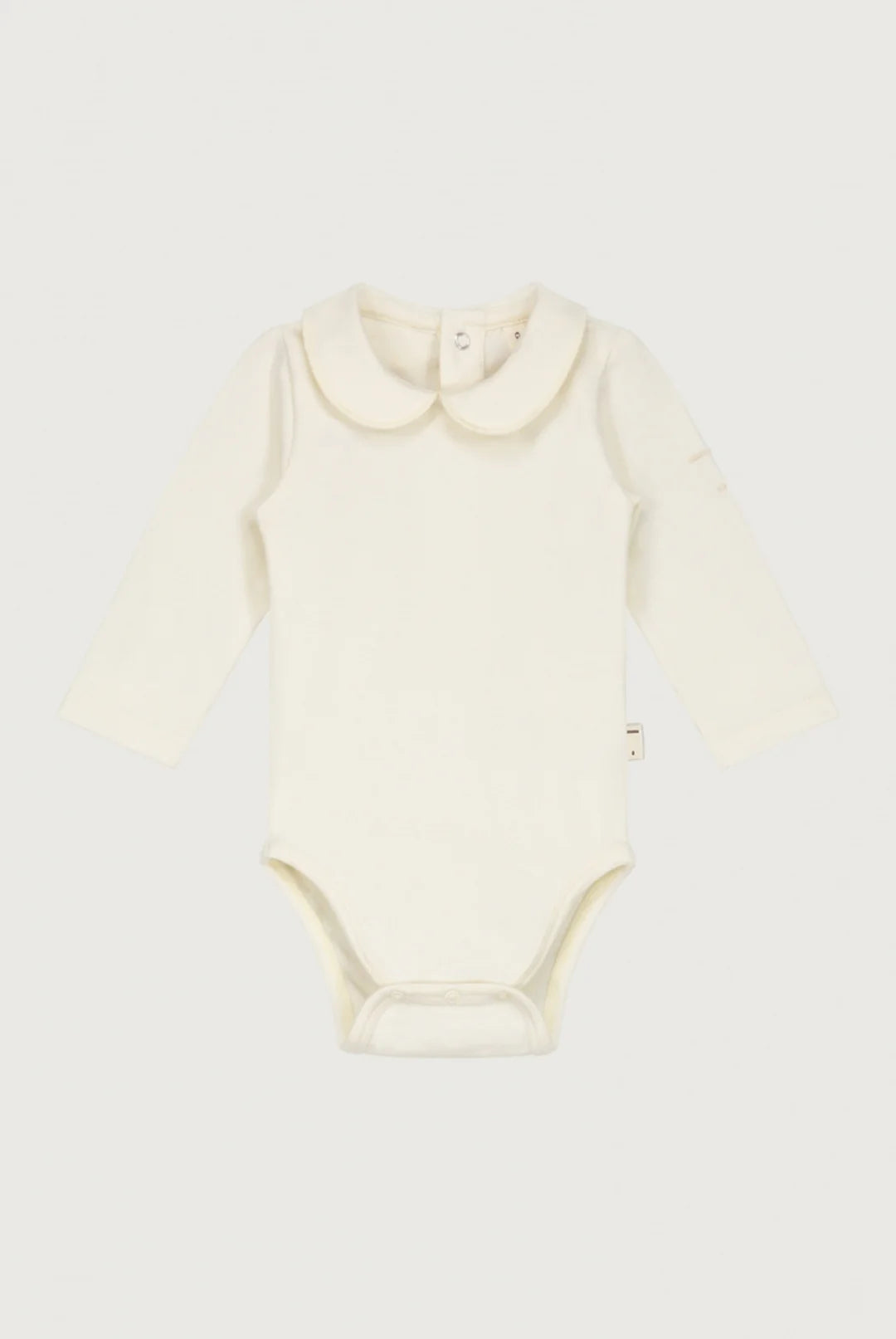 An off-white long-sleeve baby bodysuit laid flat against a light gray background.