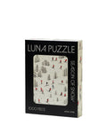 A 1000-piece jigsaw puzzle box titled 'LUNA PUZZLE' by the brand chic chic, featuring a winter scene illustration of skiers on a snowy hill. The box is black on the front with a large window showing the puzzle design, and has a cream-colored spine.