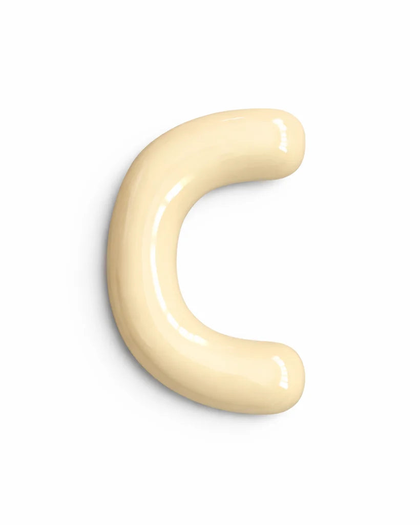A glossy, curved letter 'C' shaped object in a pale cream or light beige color, isolated on a solid white background.