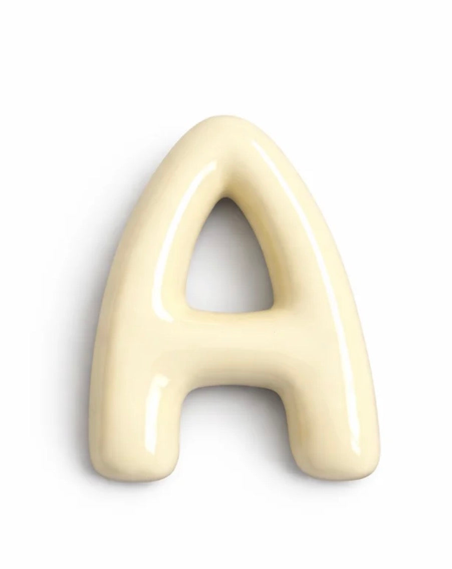 A glossy, 3D decorative letter 'A' in a warm cream or ivory color, shown on a plain white background.