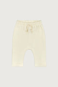 Cream-colored knit baby pants with an elastic waistband and drawstring, shown flat on a light gray background.