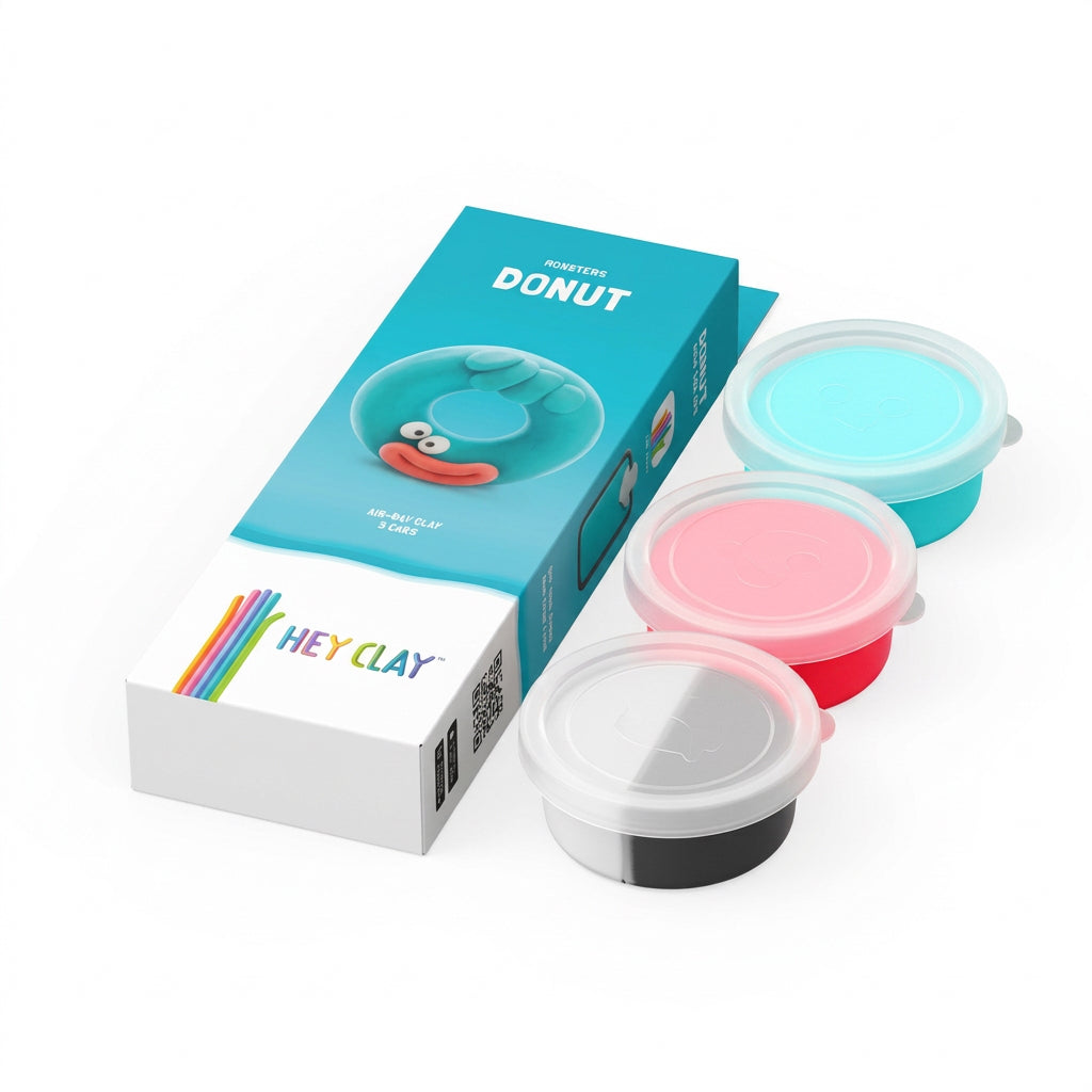 HEY CLAY mini clay pots and packaging box on a white background. The set includes a blue box with a cartoon donut graphic, three small round plastic pots in light blue, pink, and red, and a white pot with a black bottom, all showing the HEY CLAY brand.