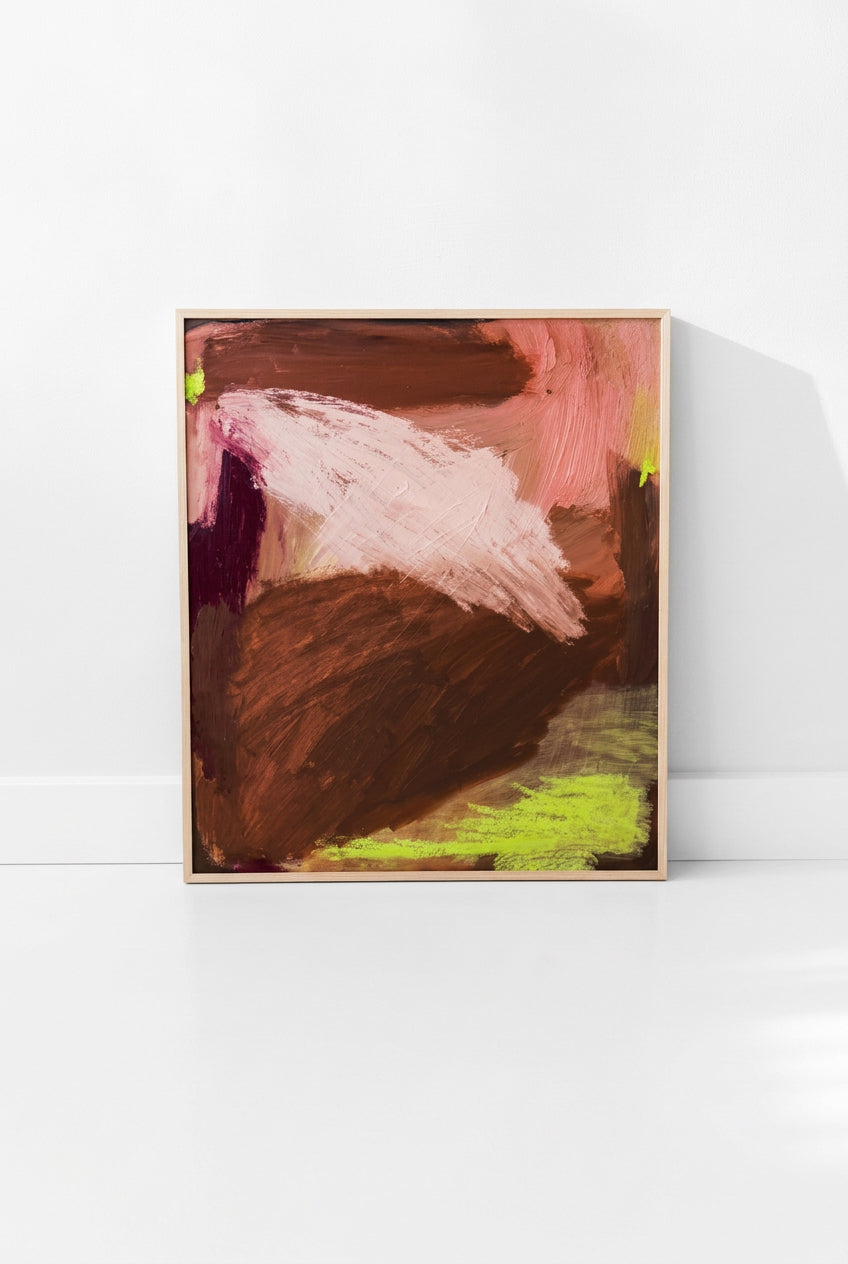 A framed abstract painting leaning against a beige wall on a light floor. The artwork features textured brushstrokes in brown, dusty pink, burgundy, and lime green, enclosed in a light wood frame.