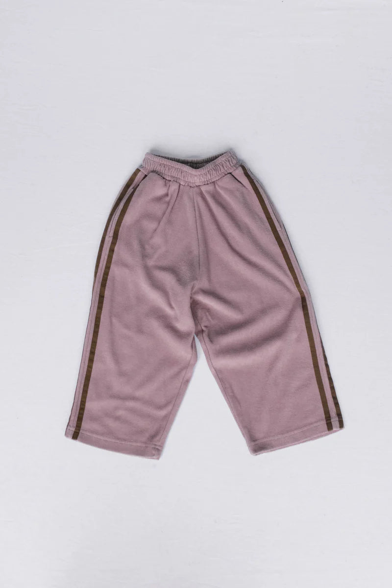 A pair of dusty pink cropped sweatpants with dark brown stripes down the sides, laid flat on a light gray background.