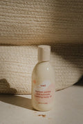 Bottle of Kenko body oil on a textured surface