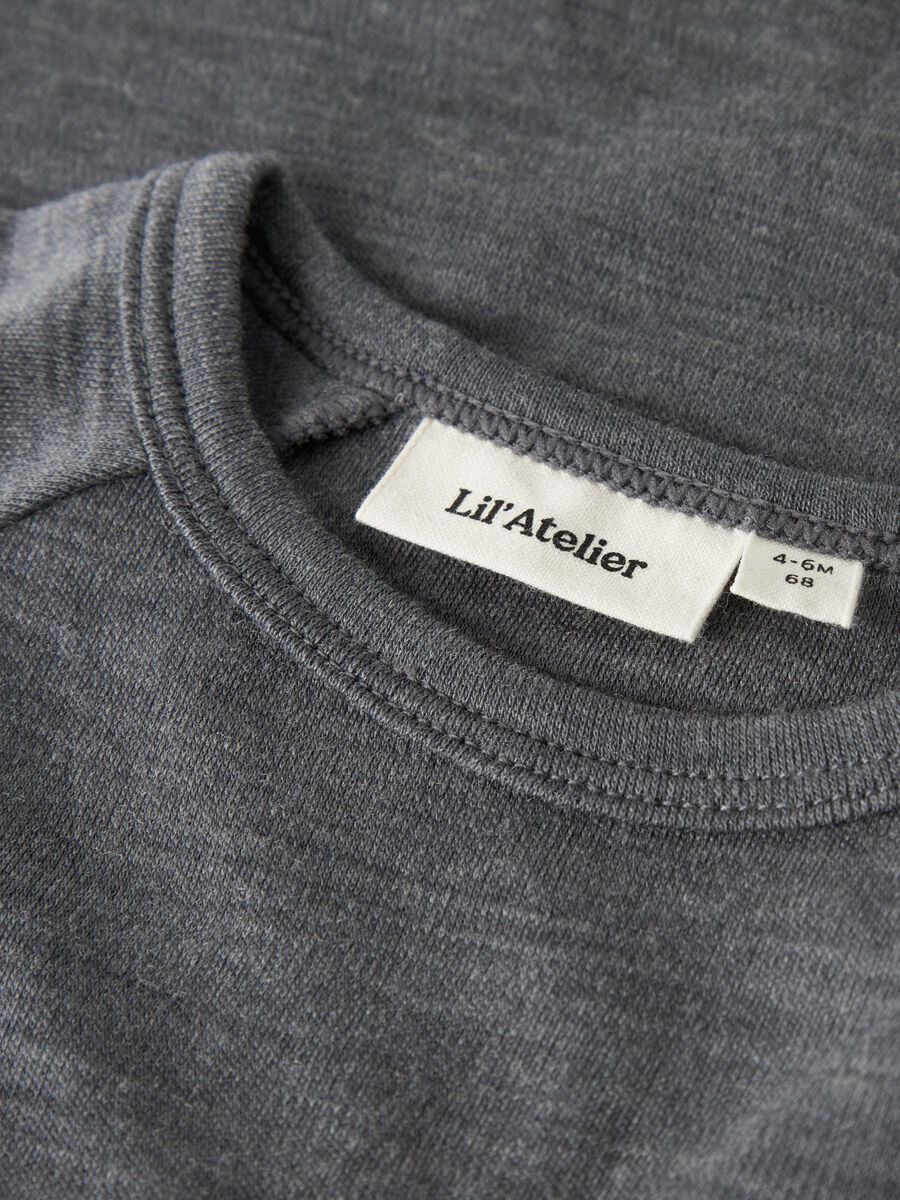 Close-up of a dark gray crewneck t-shirt showing the inner neck label which reads 'Lil'Atelier'.