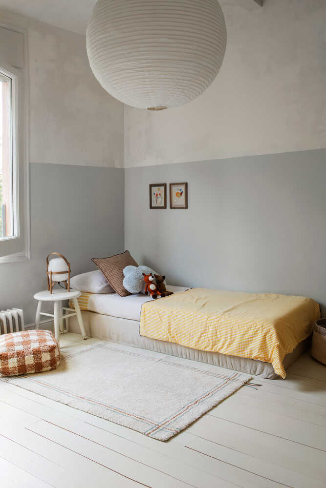 Children's bedroom with a bed, toys, and a small table.