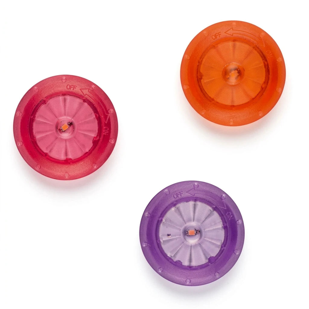 Three translucent plastic round knobs in pink, orange, and purple, arranged on a plain white background.