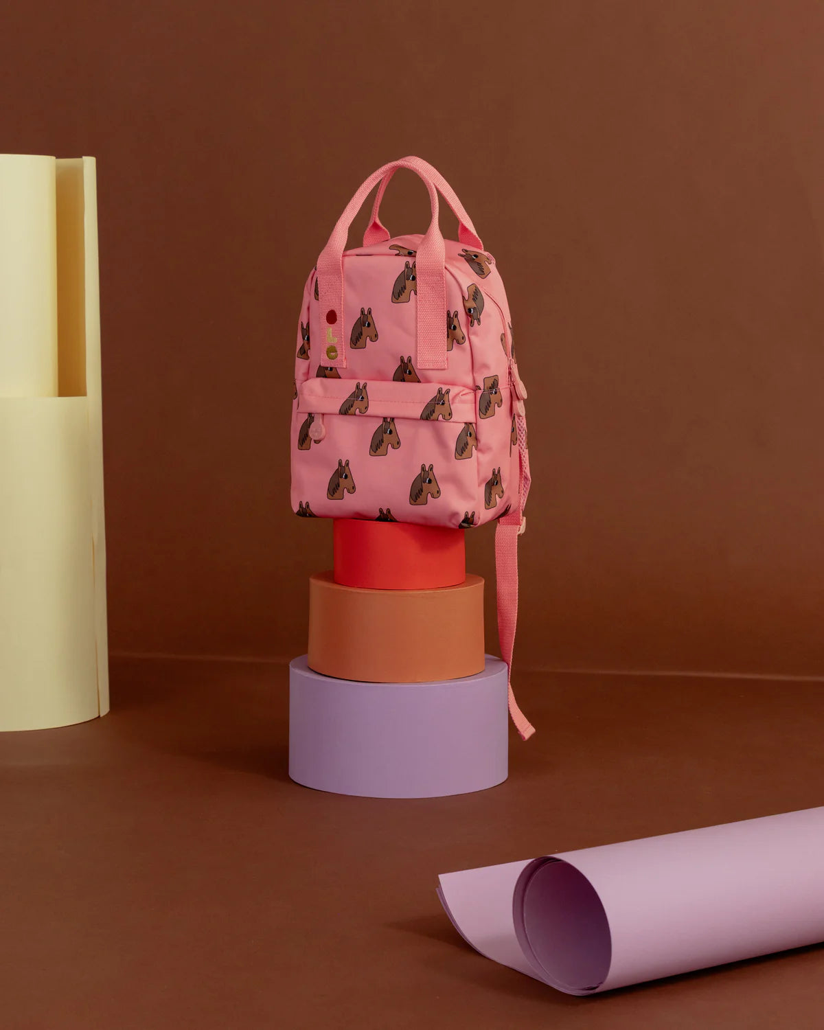 Pink backpack with brown  patterns on a brown background