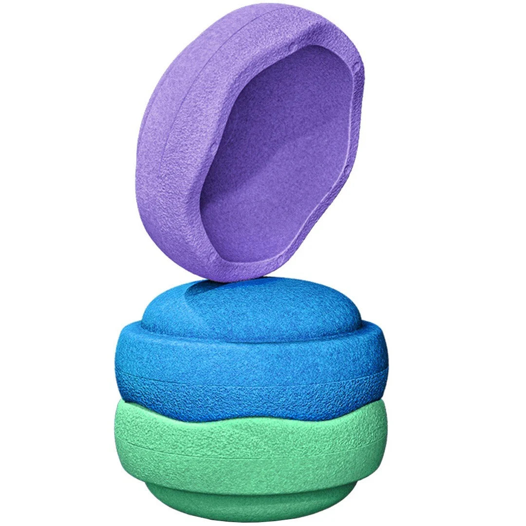 Three textured foam pet toys stacked vertically on a white background, with the top purple toy leaning against the others.