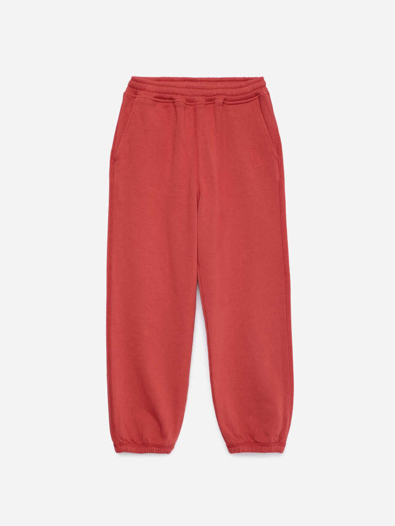 A pair of dusty red sweatpants with an elastic drawstring waist and elastic cuffs, shown flat against a light gray background.
