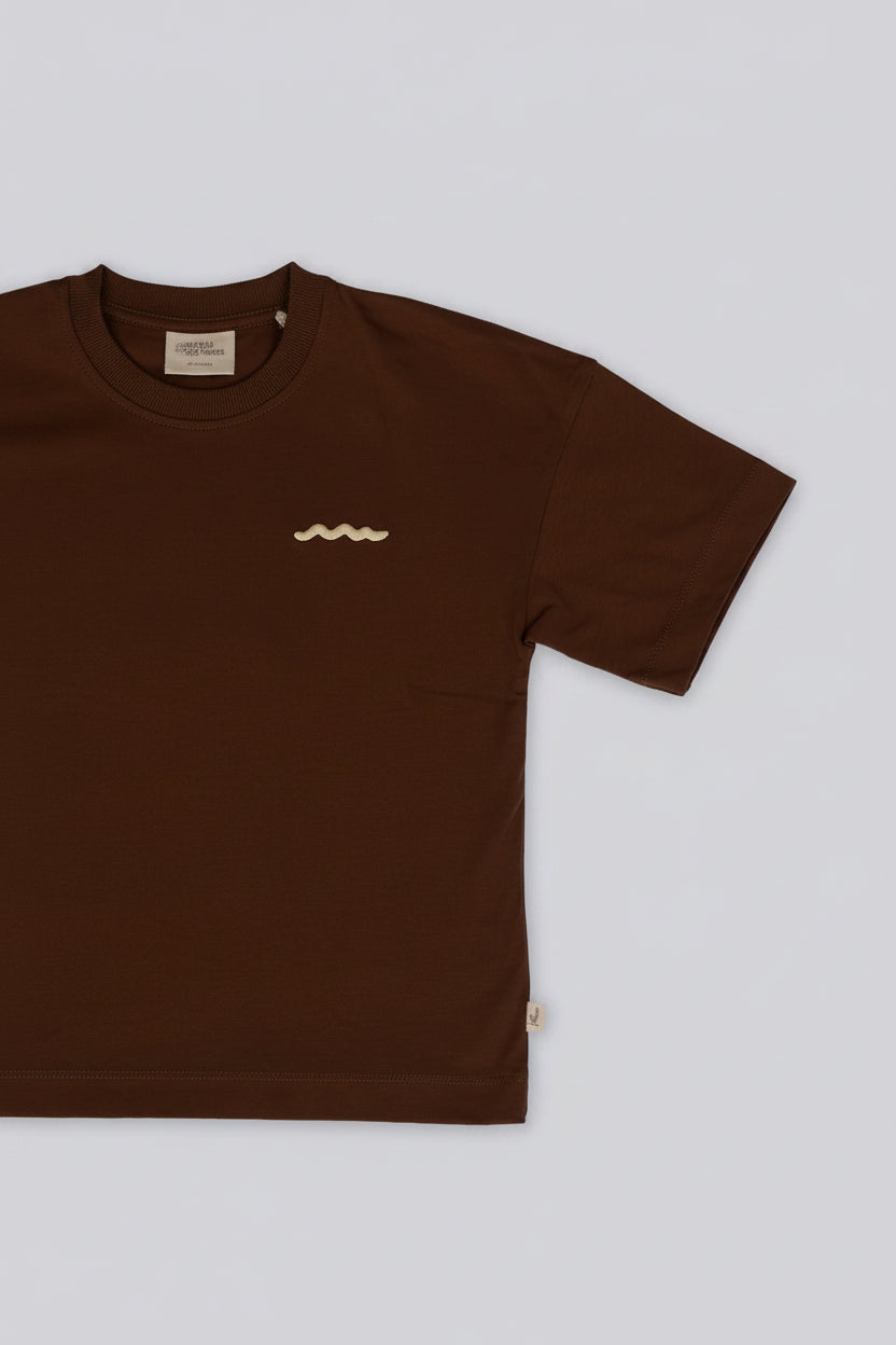 Brown t-shirt with a small logo on a light gray background