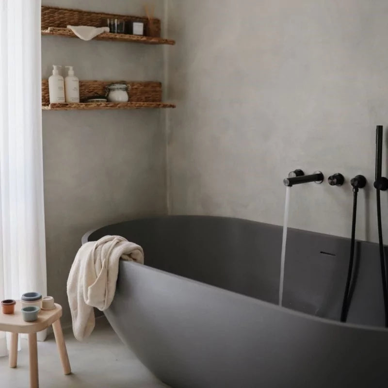 Modern bathroom with a freestanding bathtub, shelves, and minimal decor.