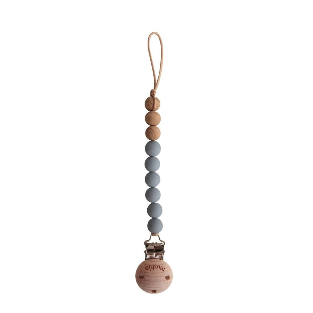 Beaded pacifier clip with wooden base on a white background