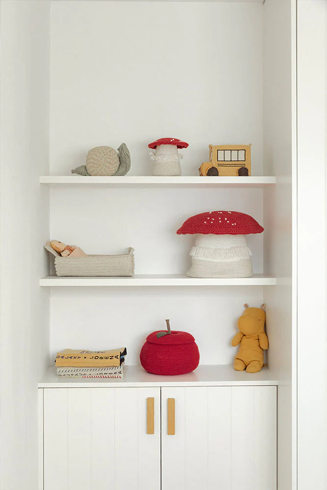 White bookshelf with decorative items including a red mushroom-shaped lamp and a teddy bear and snail
